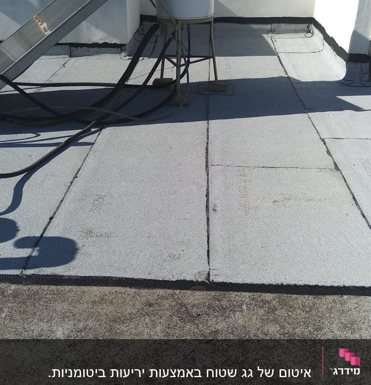 גג אטום עם יריעות ביטומניות ומיכל מים